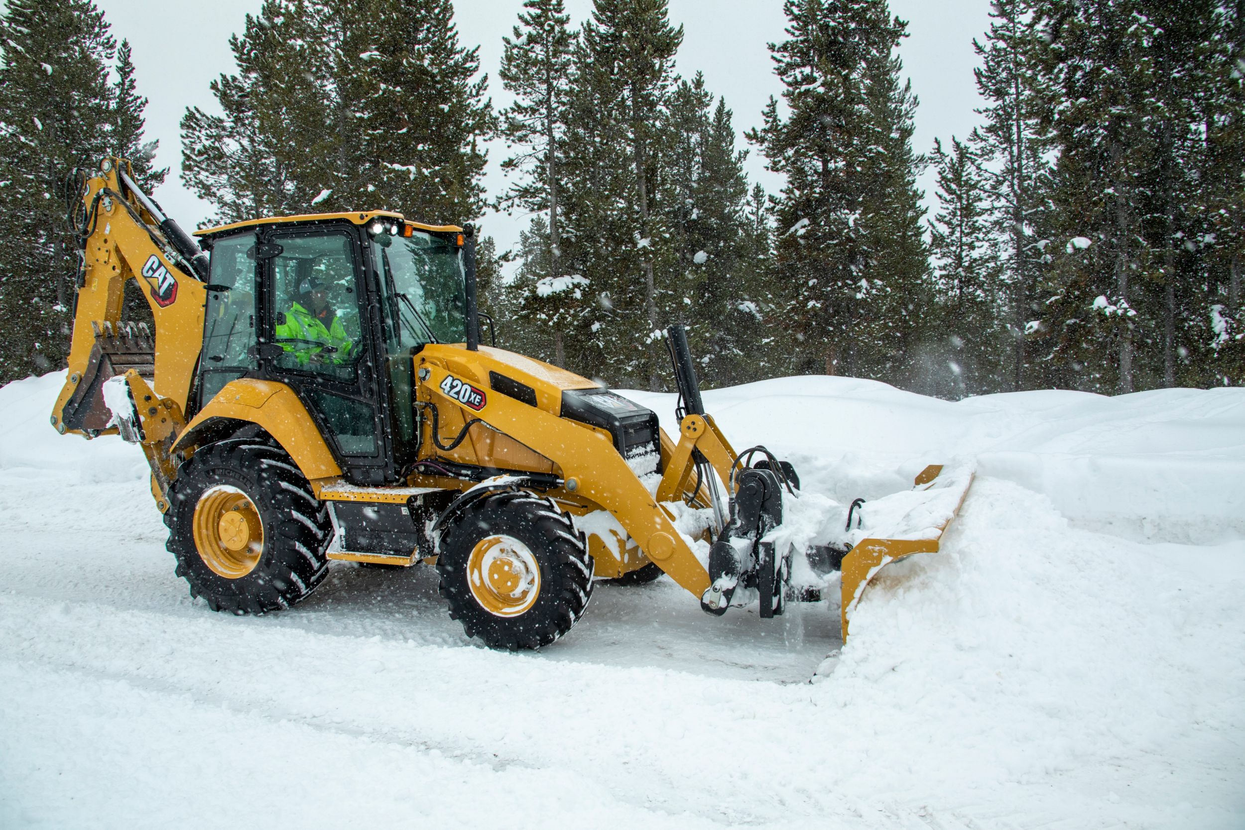 A backhoe loader pushing snow.
