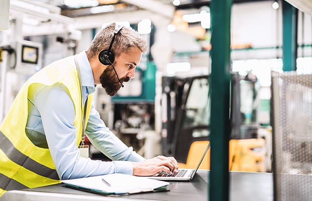 Engineering Consultant using a laptop in a factory