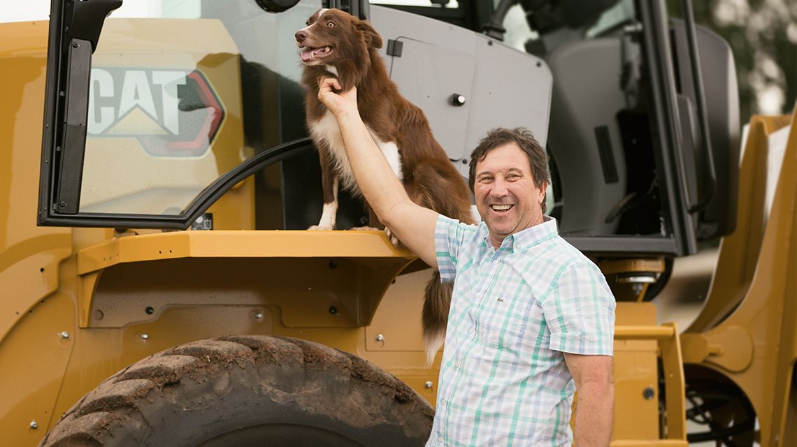 Older male customer sitting wearing Caterpillar branded hat during COVID-19 pandemic