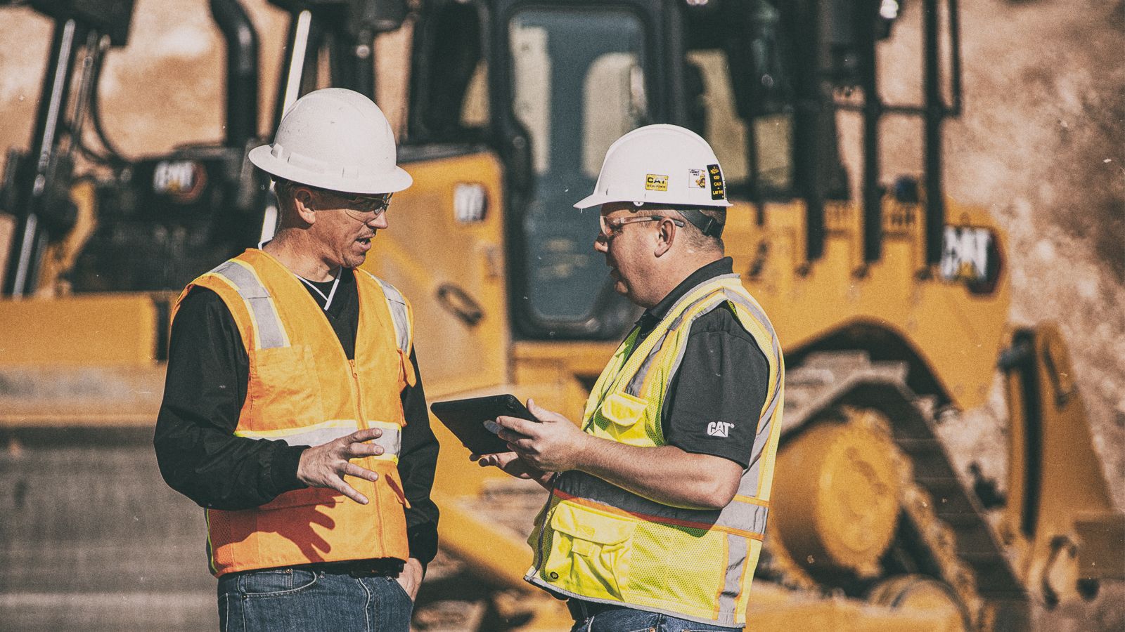 Two people talking holding a mobile tablet