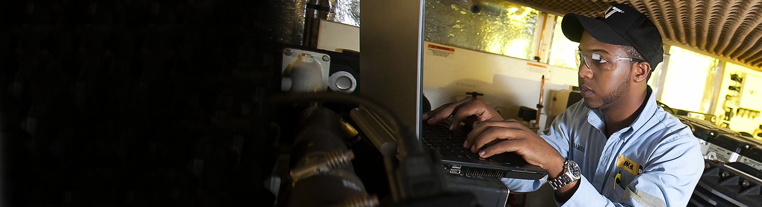 Cat dealer tech using computer to trouble shoot equipment issue