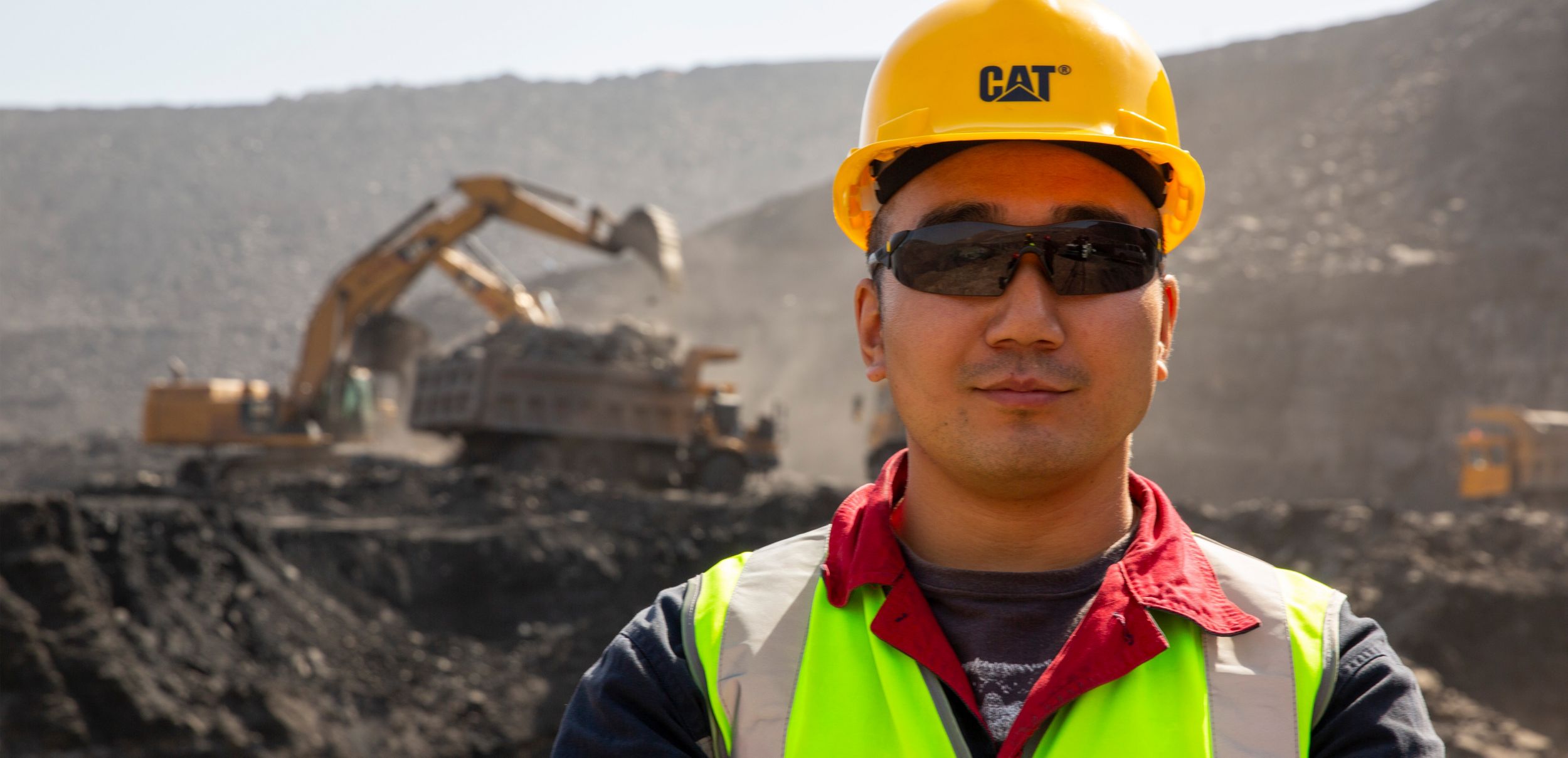 construction worker in a Cat hardhat on a jobsite