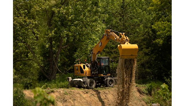 M320 wheel excavator using a bucket to move dirt