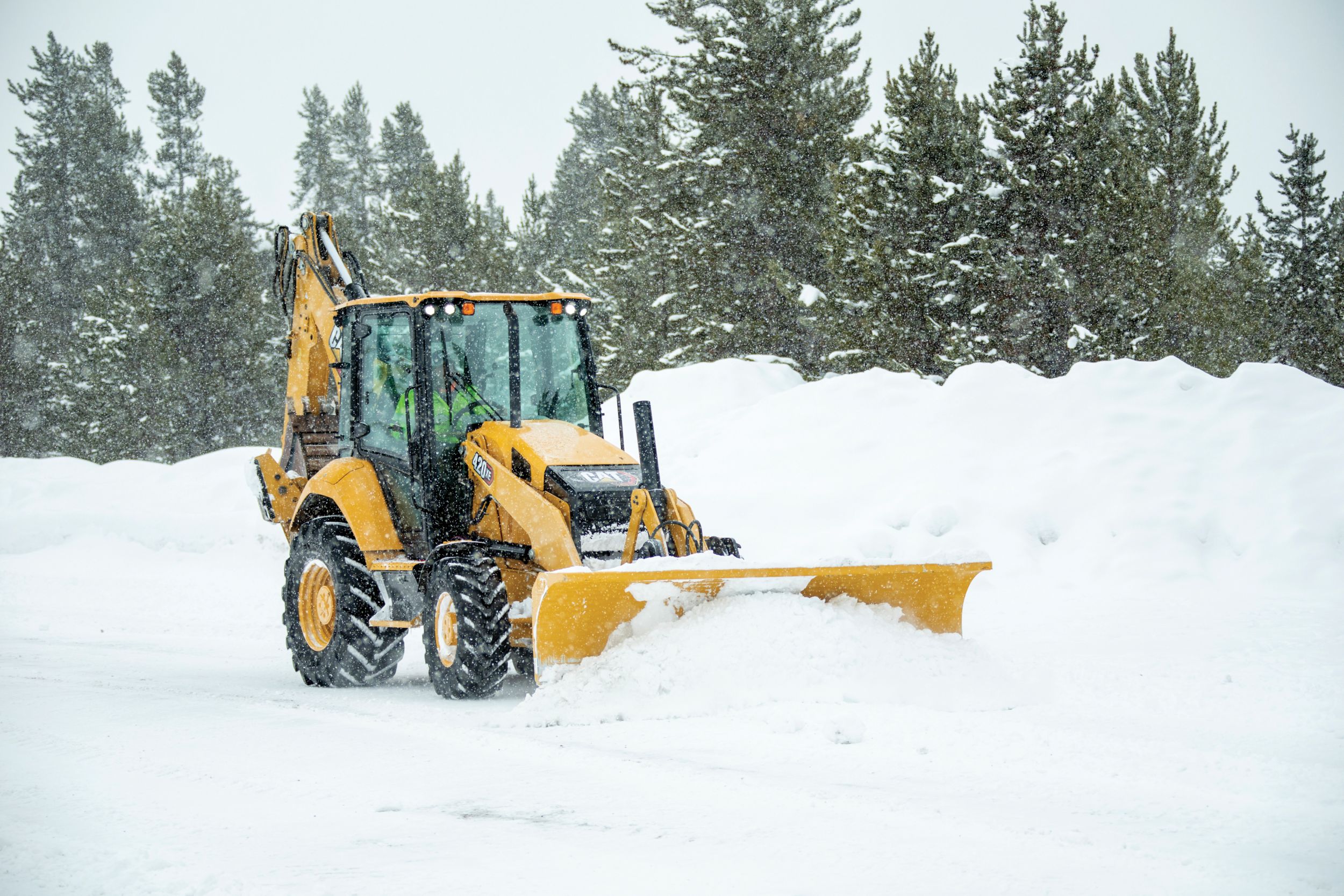 420 Backhoe in snow with plow