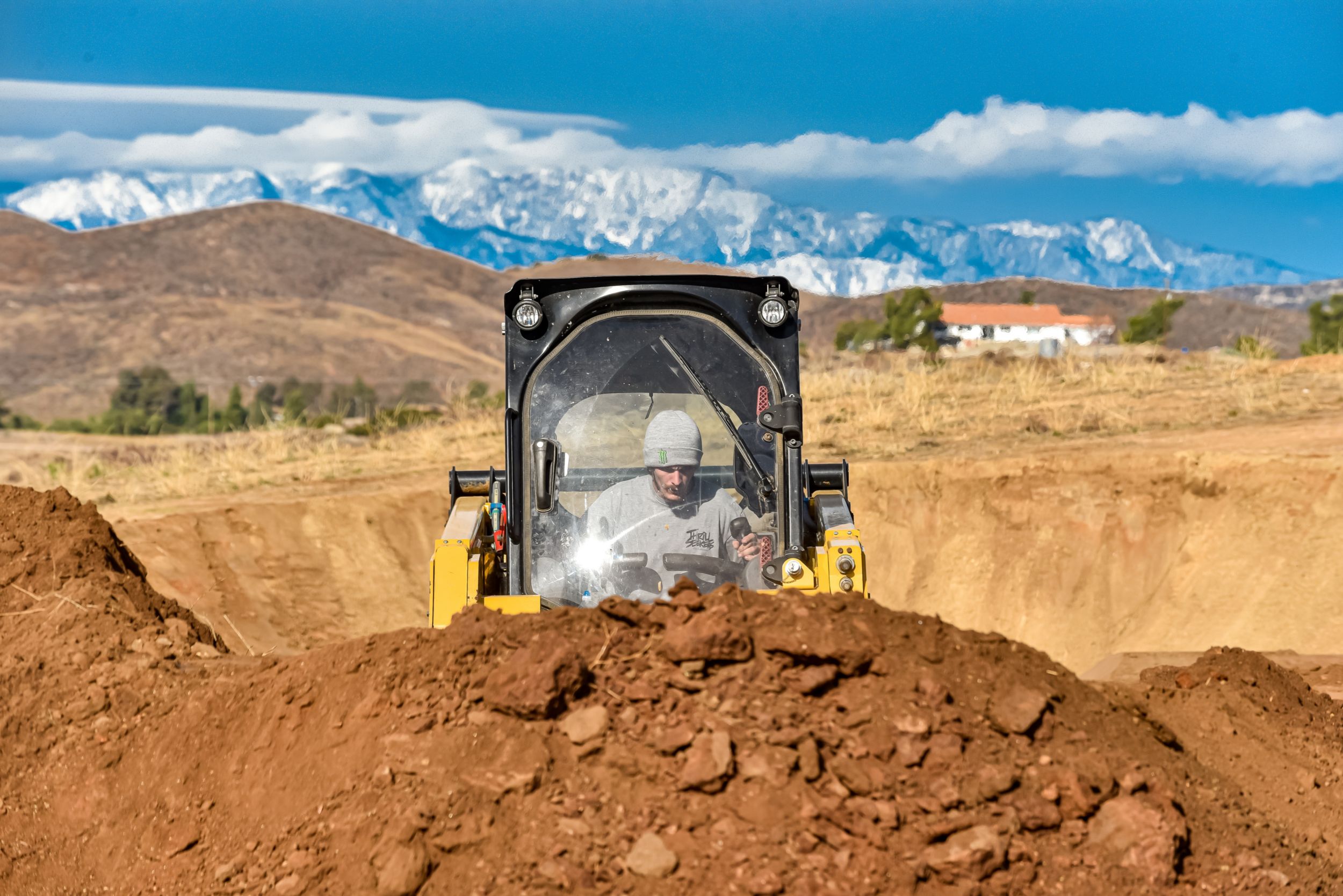 Jarryd McNeil Motocross athlete operating a Cat skid steer at his home.