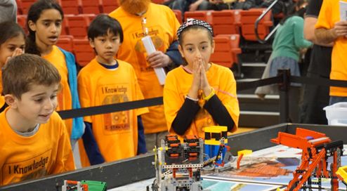 2 boys working on a robot