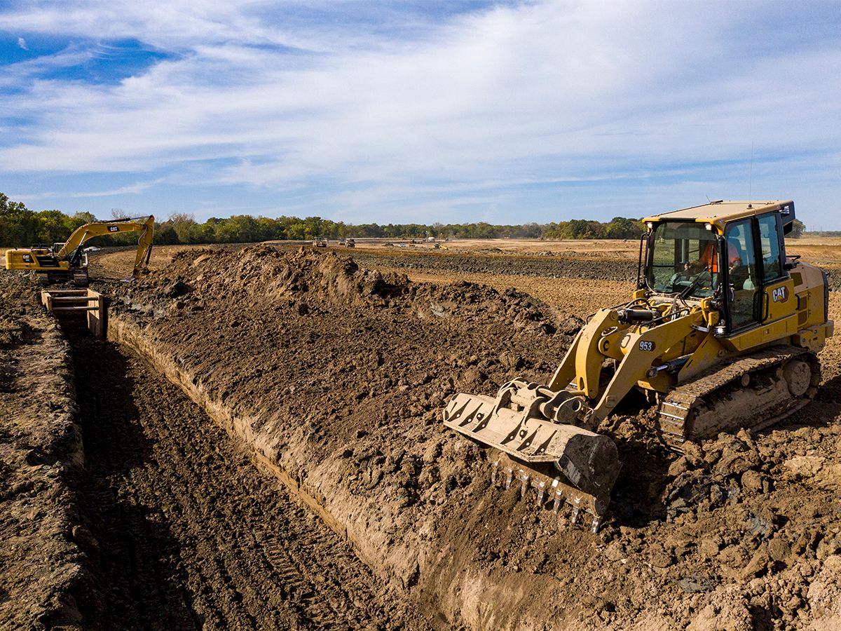 Cat 953 crawler loader filling a trench