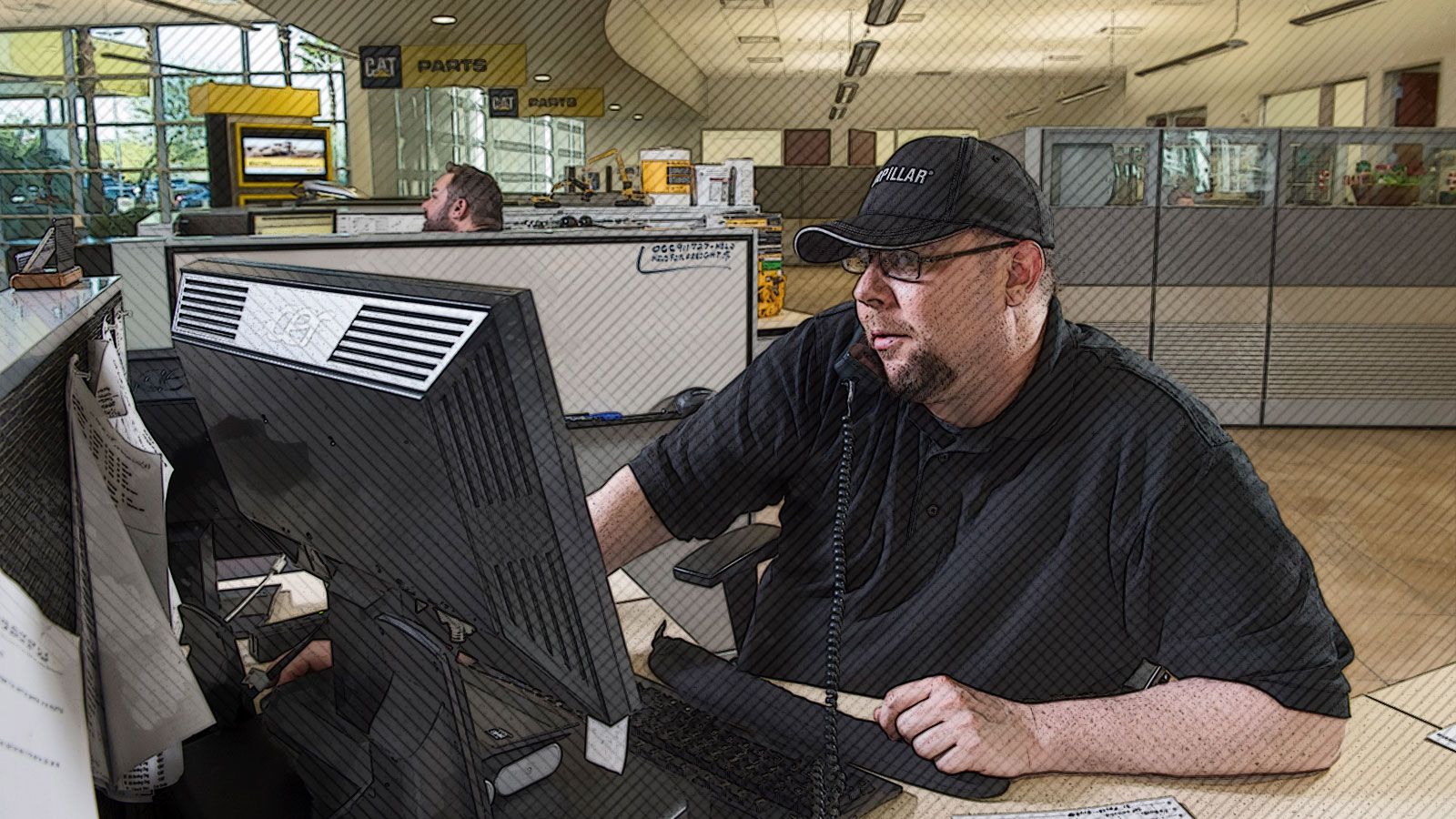 Man sitting at a computer on the phone