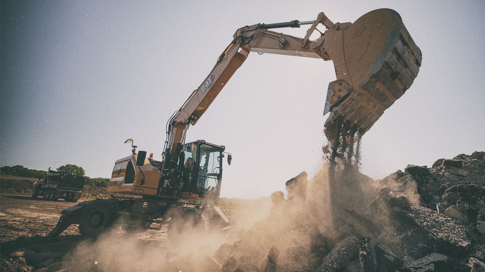 M320 Excavator pouring dirt on jobsite