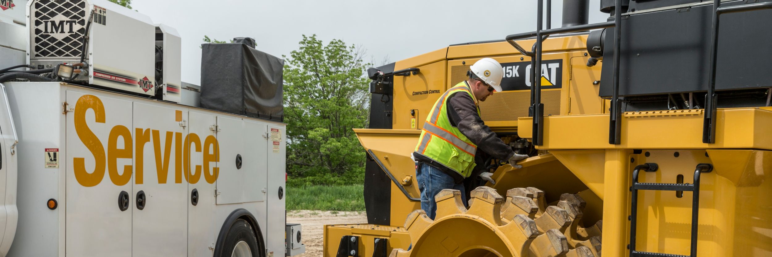 Service truck and service technician working on machine