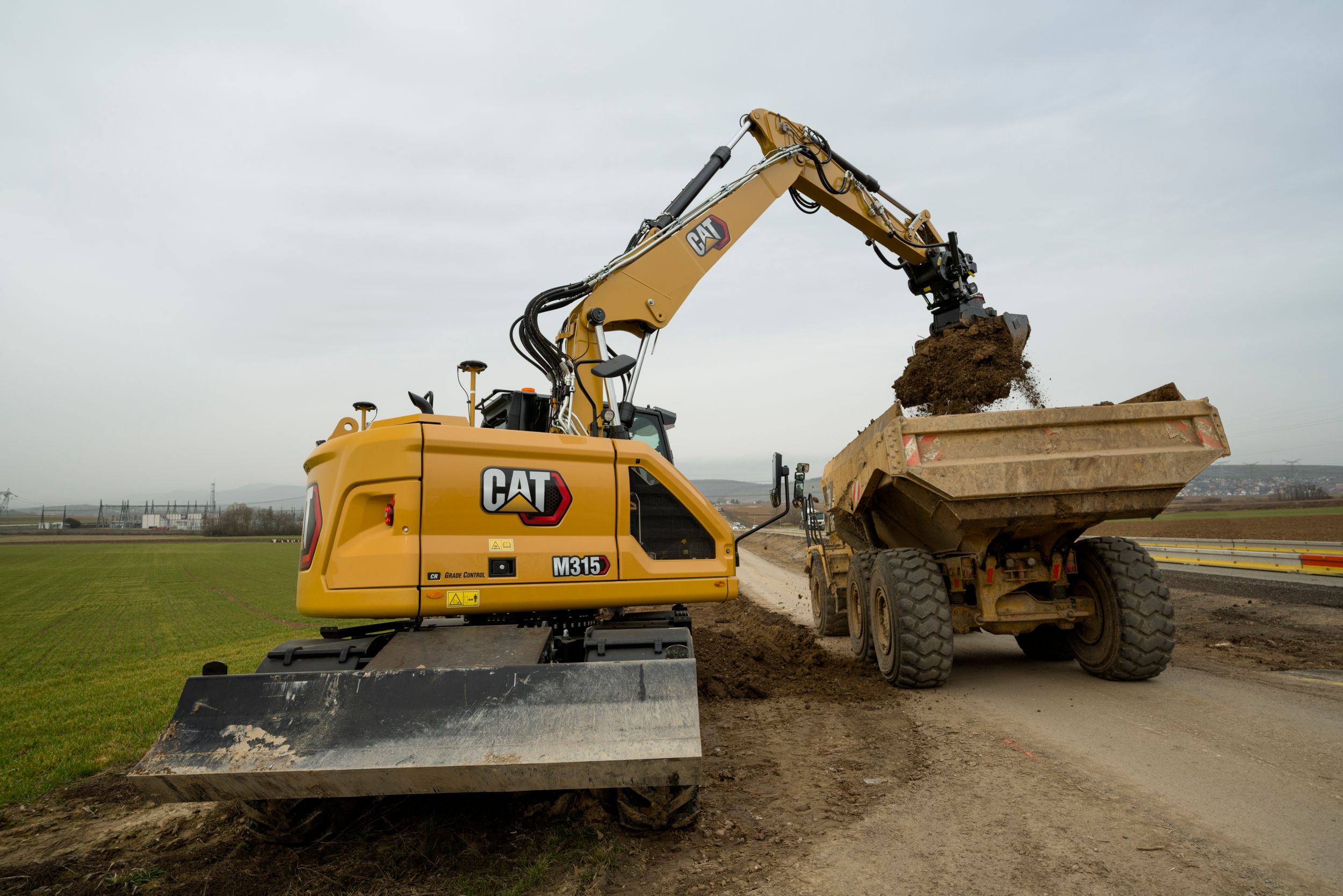 M315 Wheel Excavator loading dirt in a truck