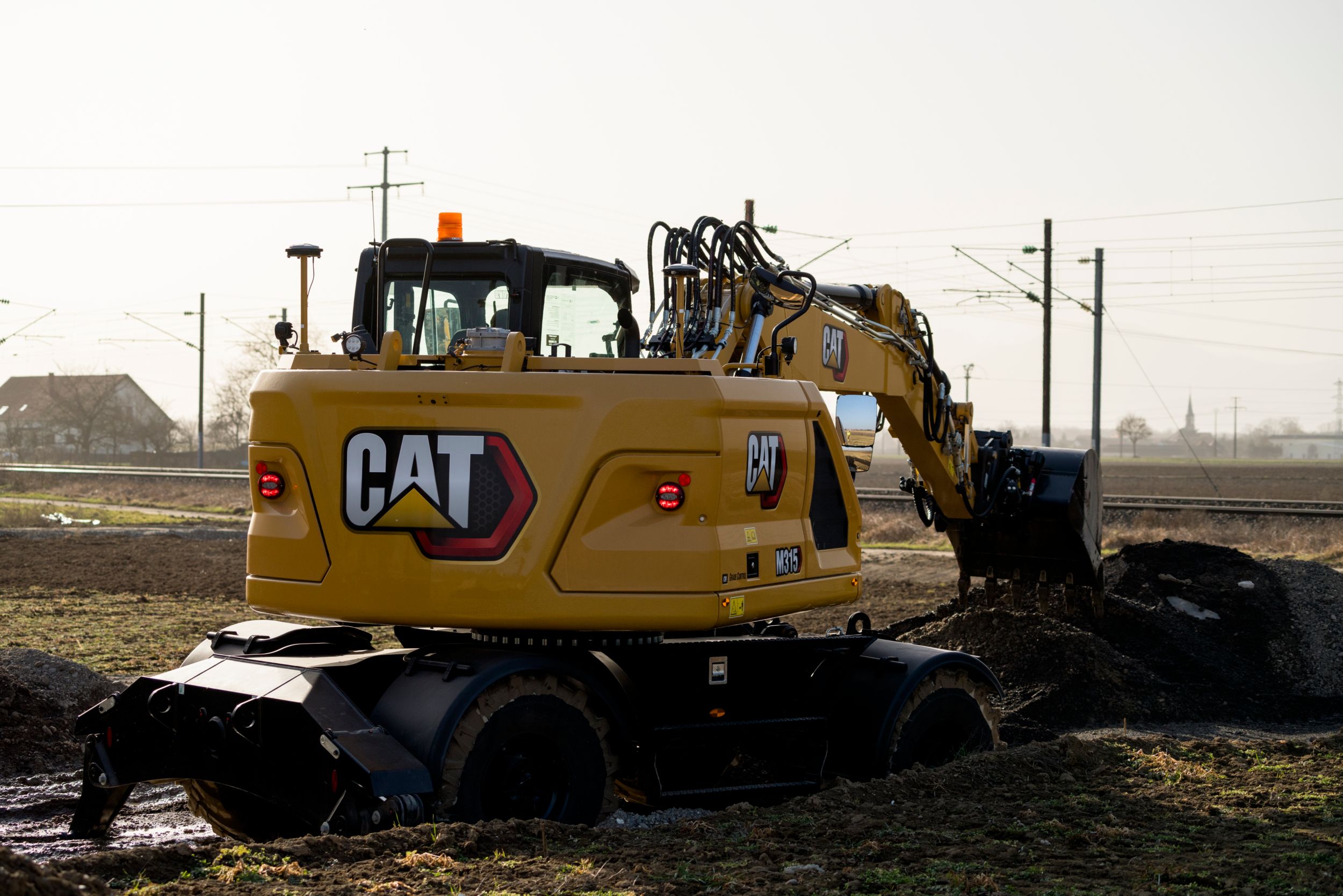 M315 Wheel Excavator moving material with a bucket