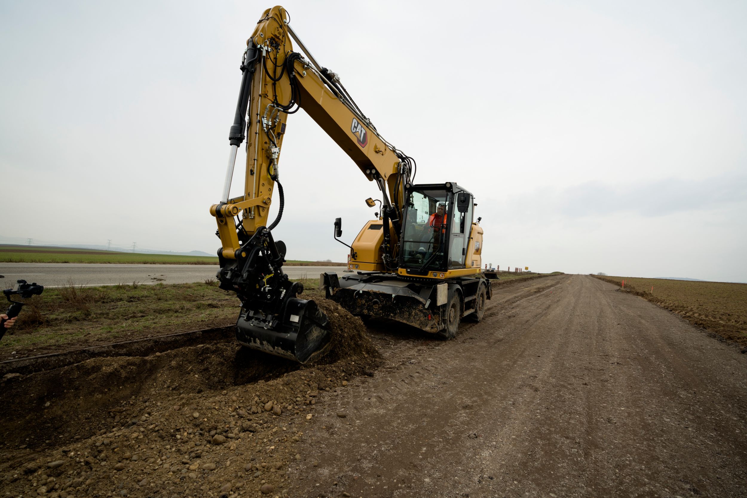 M315 Wheel Excavator digging on the side of the road