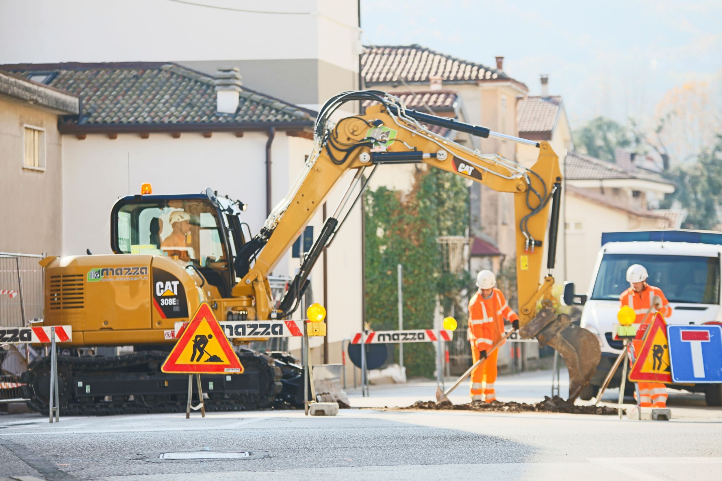 Un cliente uomo che usa un iPad con un escavatore che lavora sullo sfondo