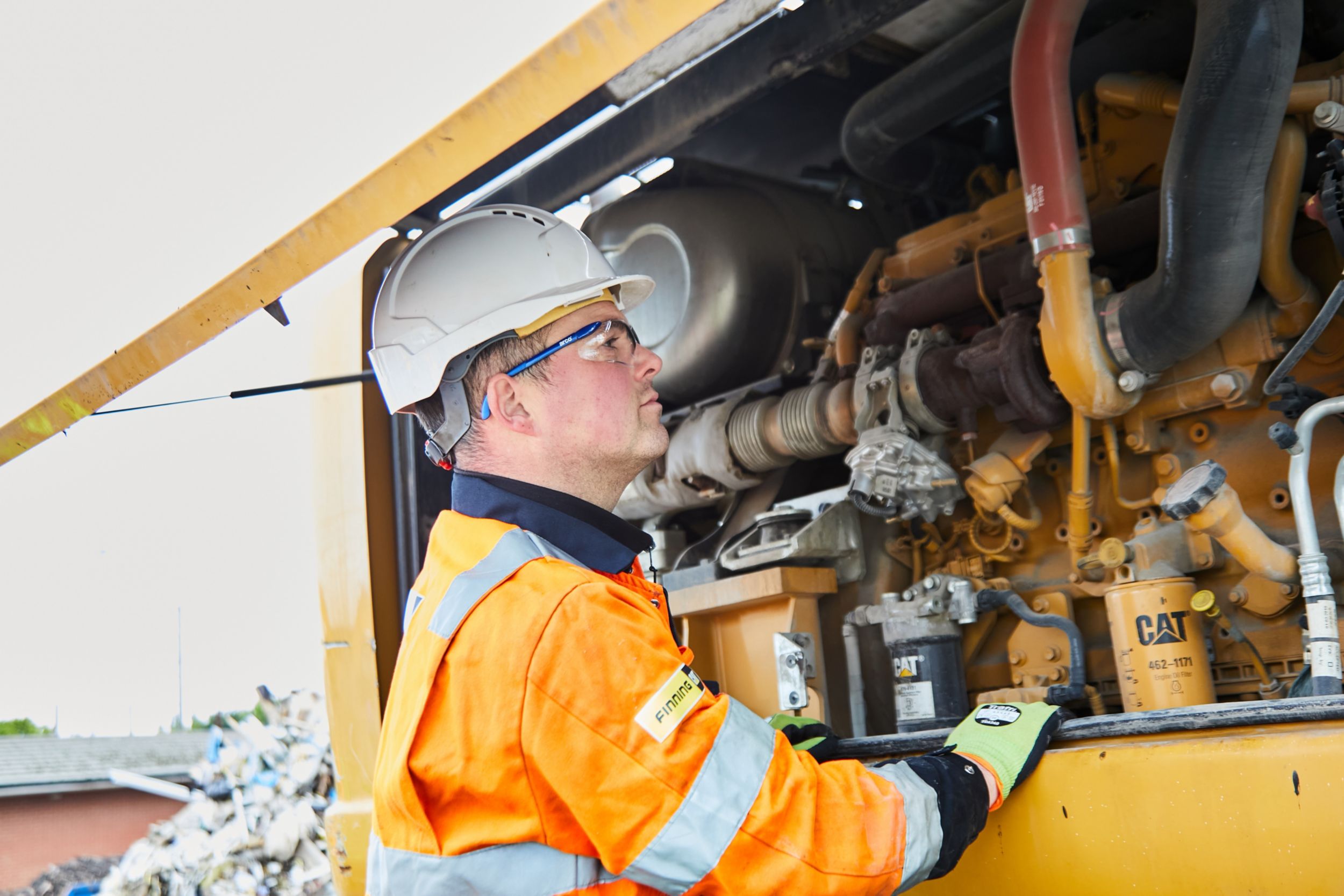Man working on engine with Cat components