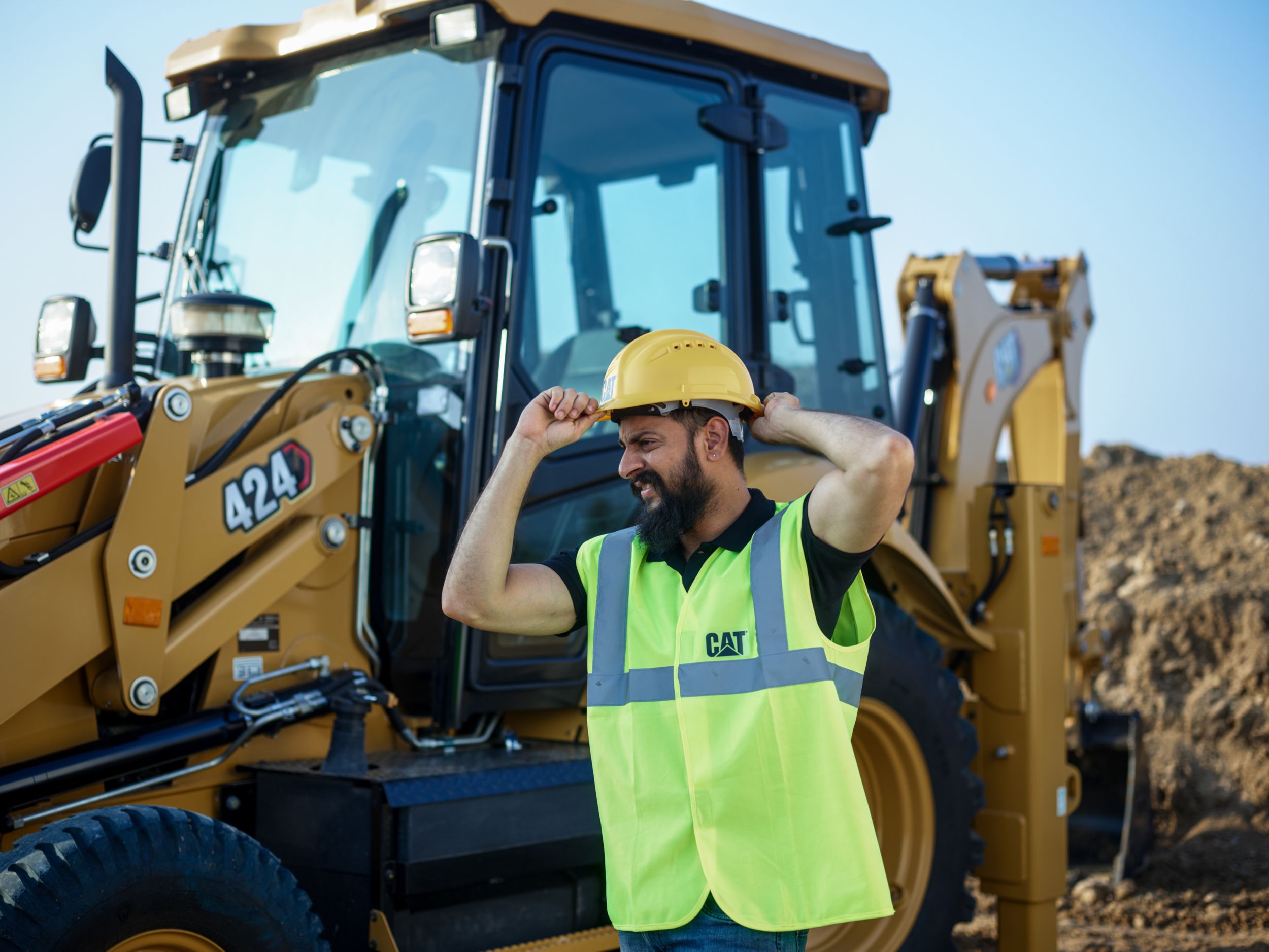 construction worker in a Cat hardhat on a jobsite