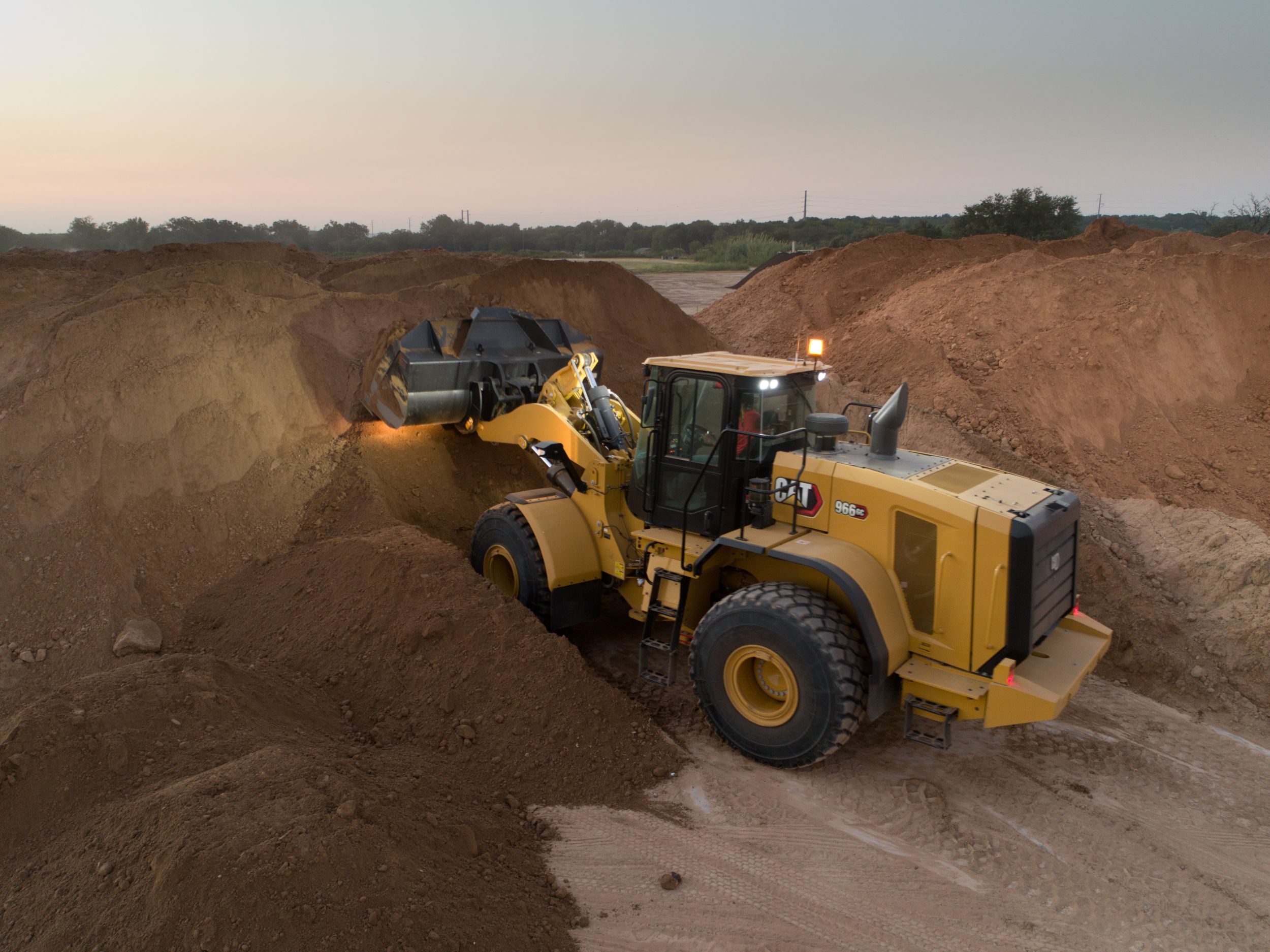 Cat 966 GC Wheel Loader Scooping Dirt with Lights on