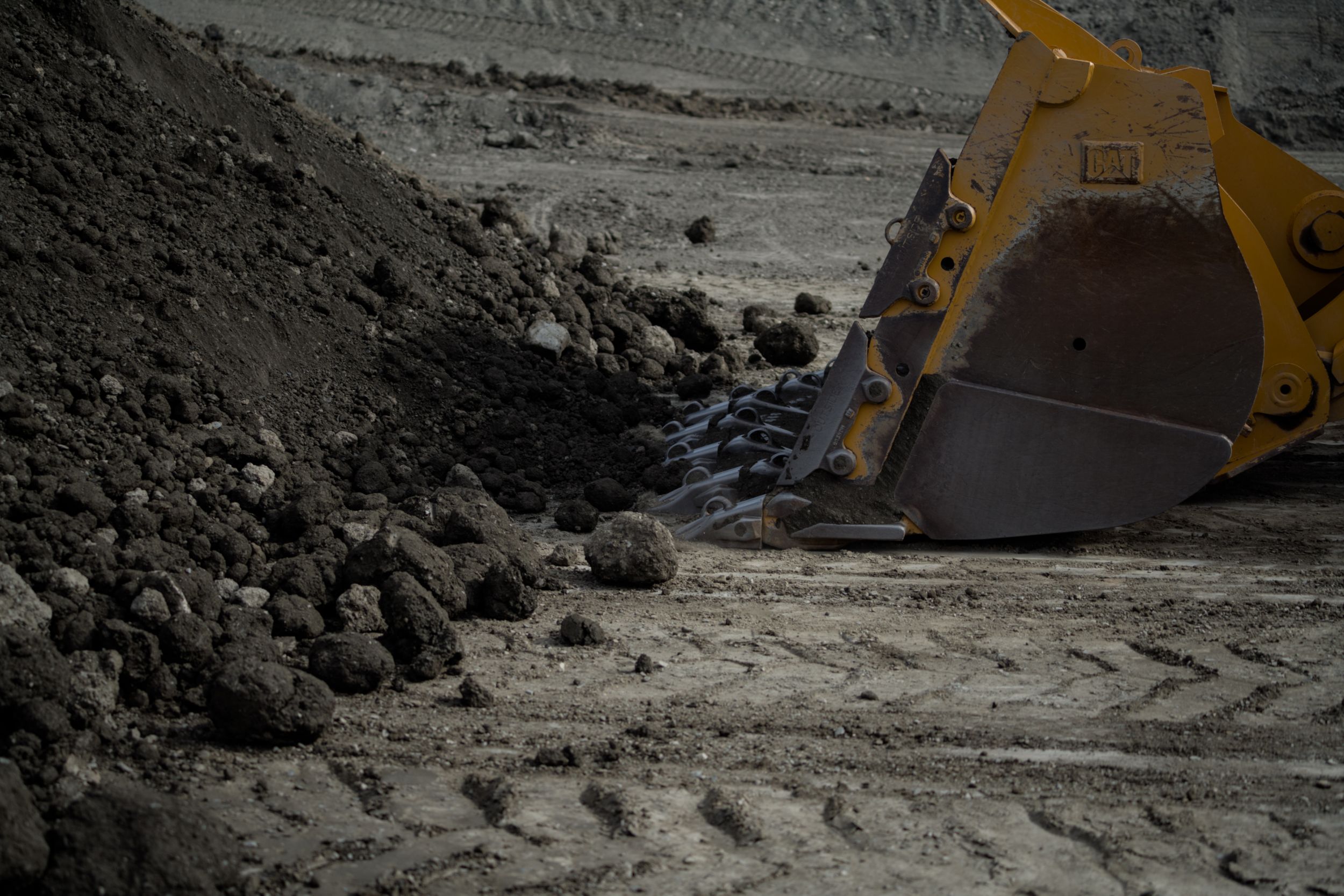 Tips on Wheel Loader Bucket near pile of dirt