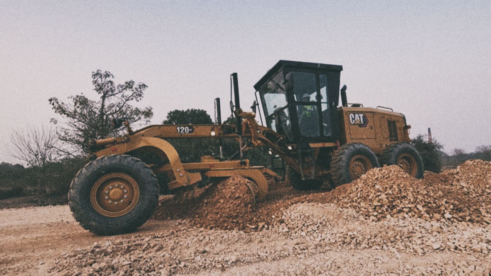 120 GC Motor Grader pushing rubble on jobsite