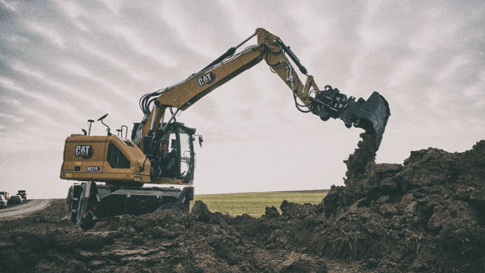 M315 Excavator pouring dirt on jobsite
