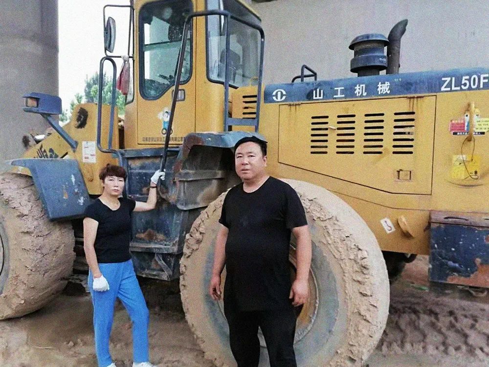 Woman and man next to wheel loader 