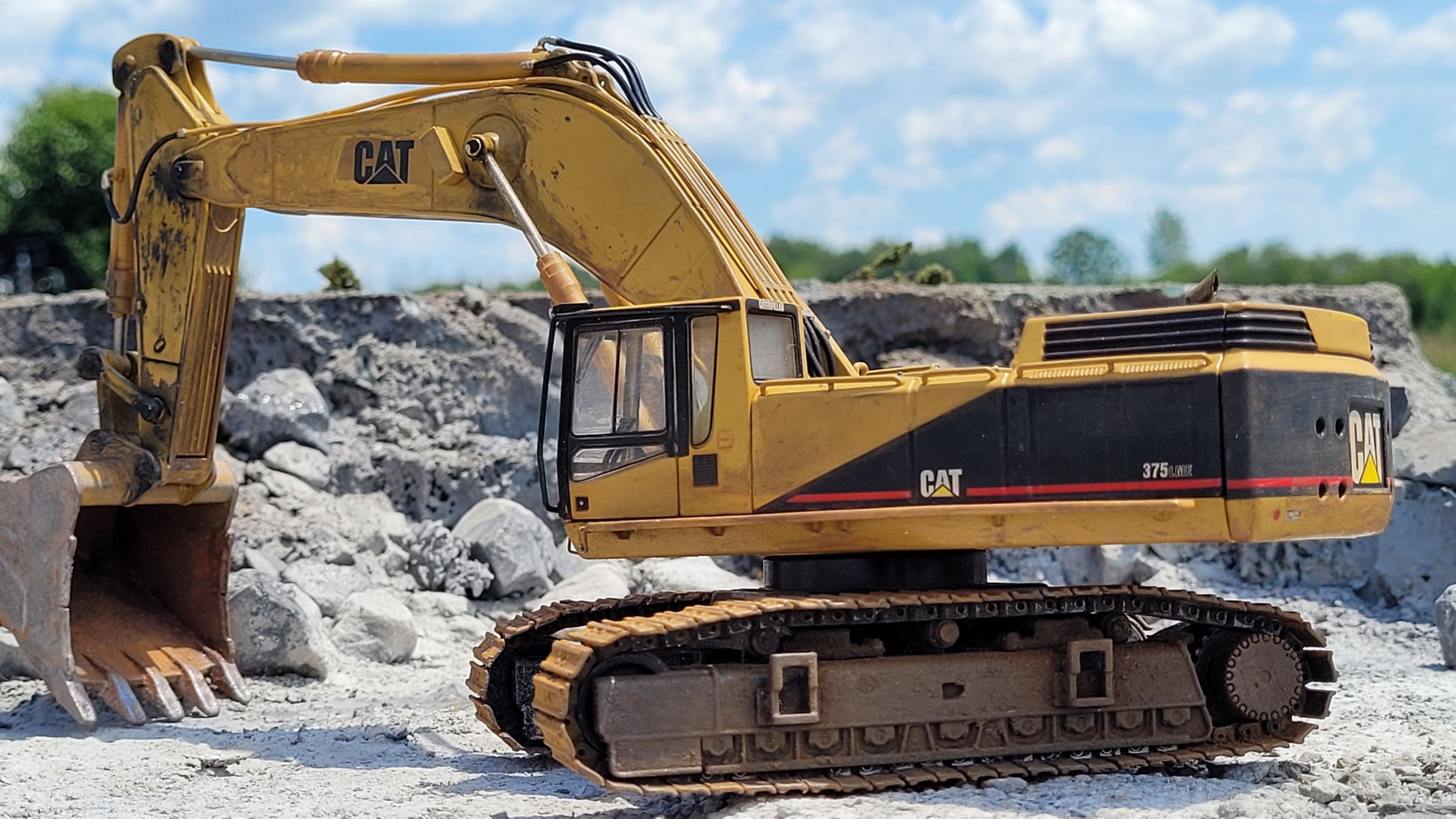 scale Cat 375 in front of a miniature quarry