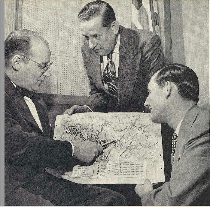 Tom Logan (left) shows section of the Alaska Highway he helped build to Caterpillar reps preparing to visit the area. 