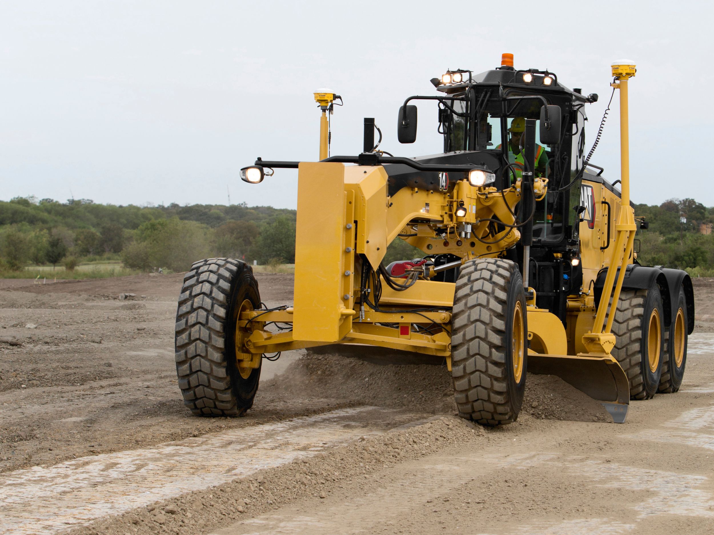 14 Motor Grader pushing earth with moldboard