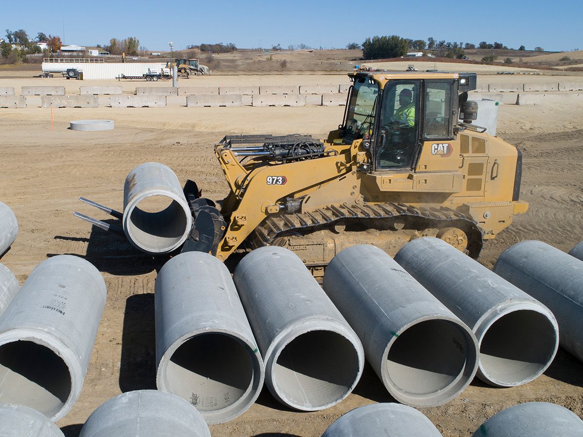 The 973 crawler loader with forks stages pipe for underground utility installation