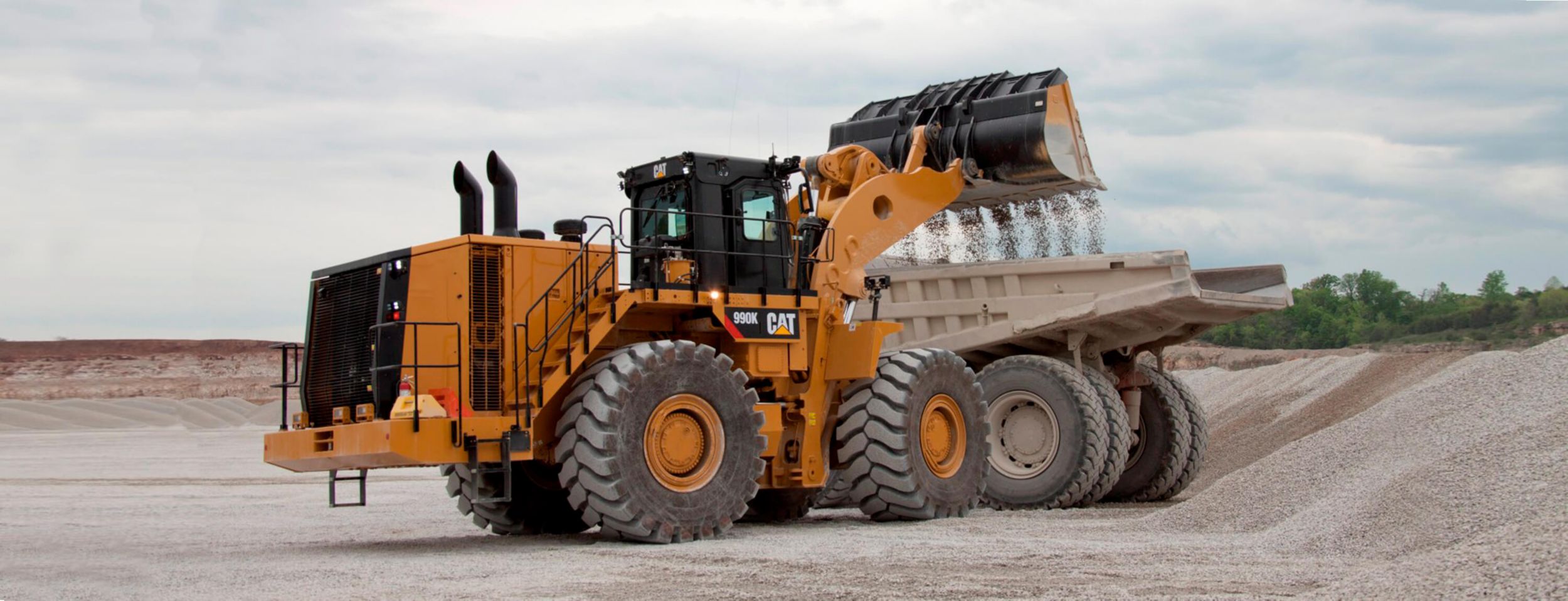 cat 990k large wheel loader loading rock into a bucket