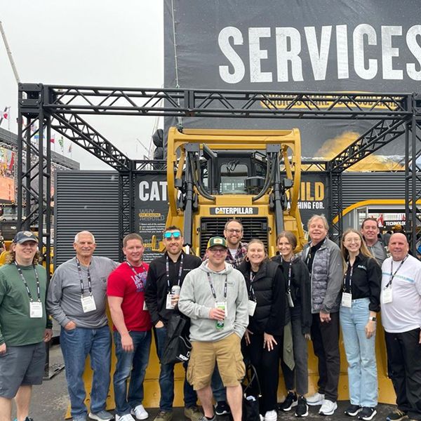 Plote Construction team poses in front of the rebuilt D6T dozer outside the services hub