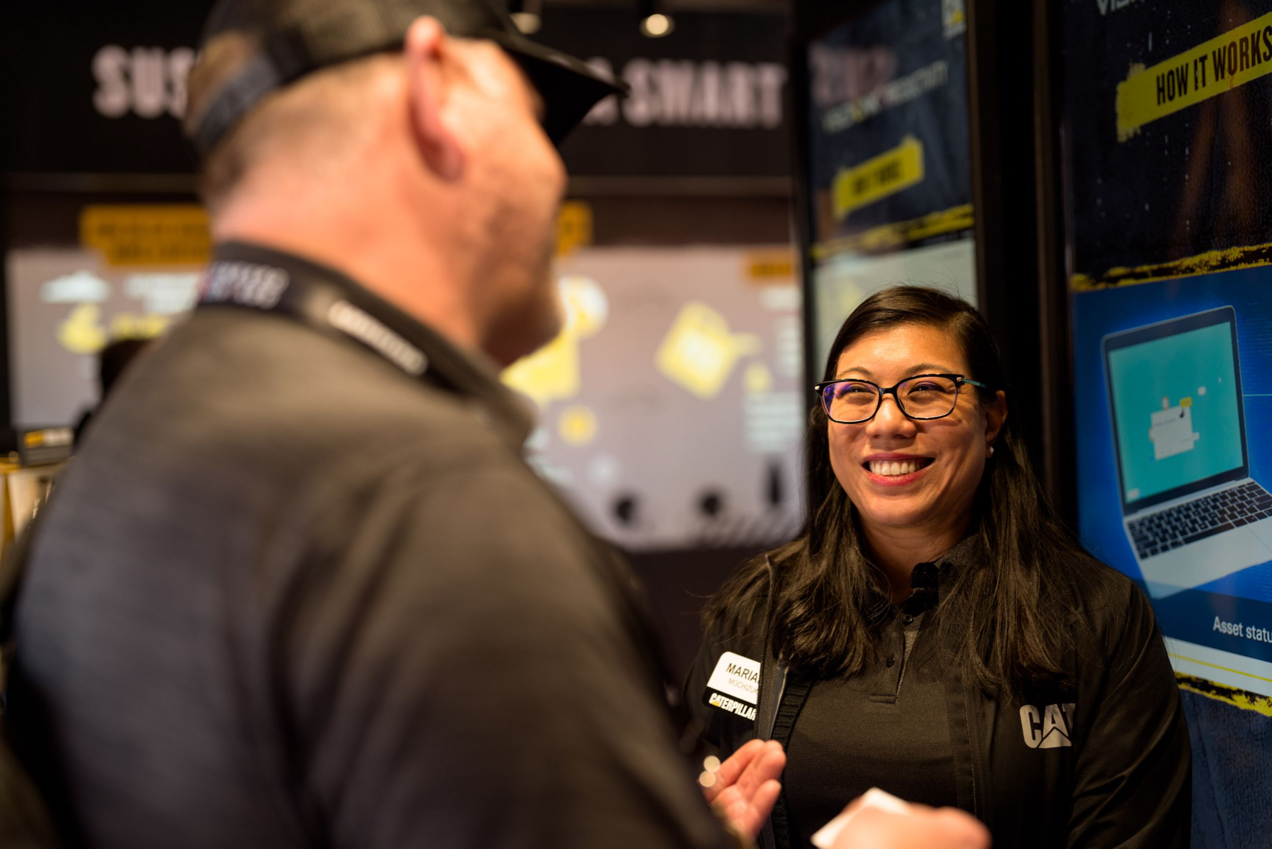 ConExpo attendees meets with a Caterpillar expert inside of the sustainability booth