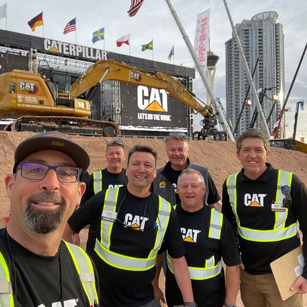 Three Caterpillar show workers pose outside Operator Stadium