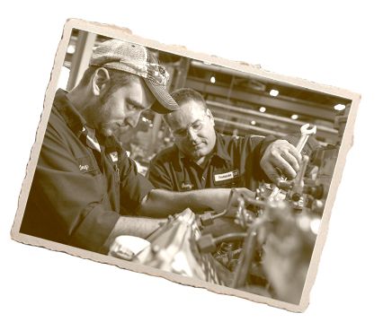 Two people working on truck engine