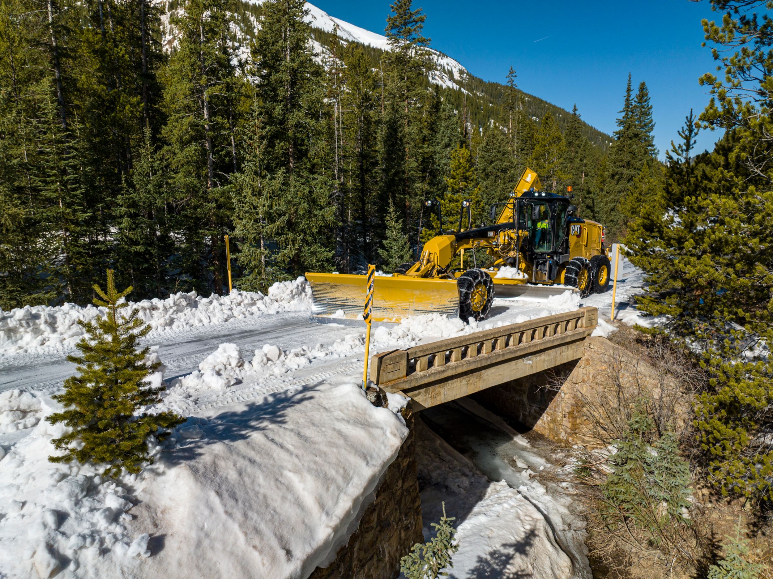Cat equipment clearing snowy road