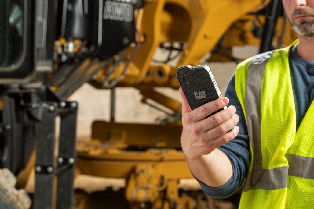 man using smartphone on job site