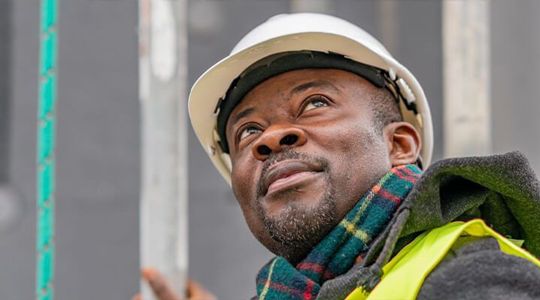 Person with hardhat looking of into the distance.
