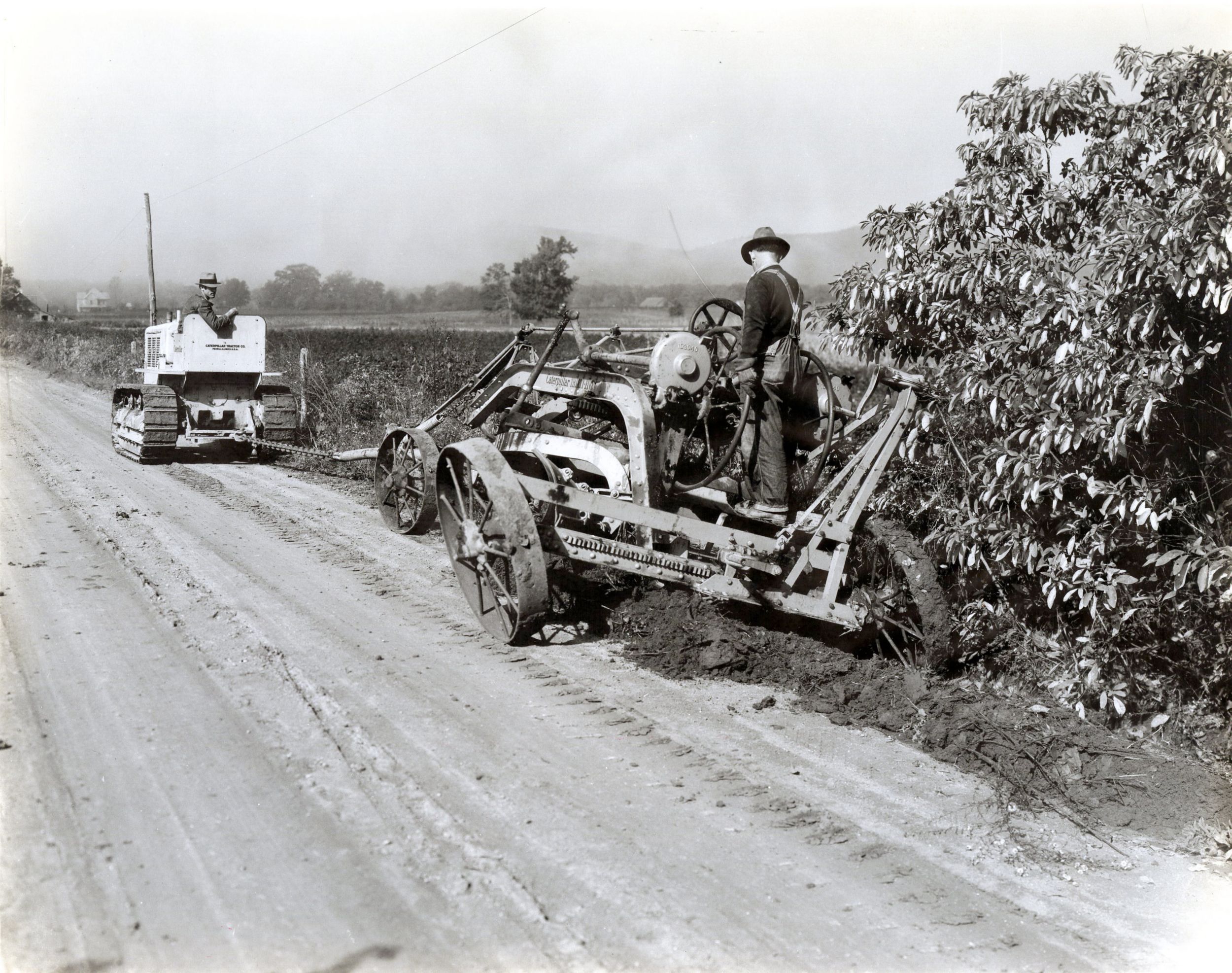 Man on Cat construction equipment cutting ditches in 1932 
