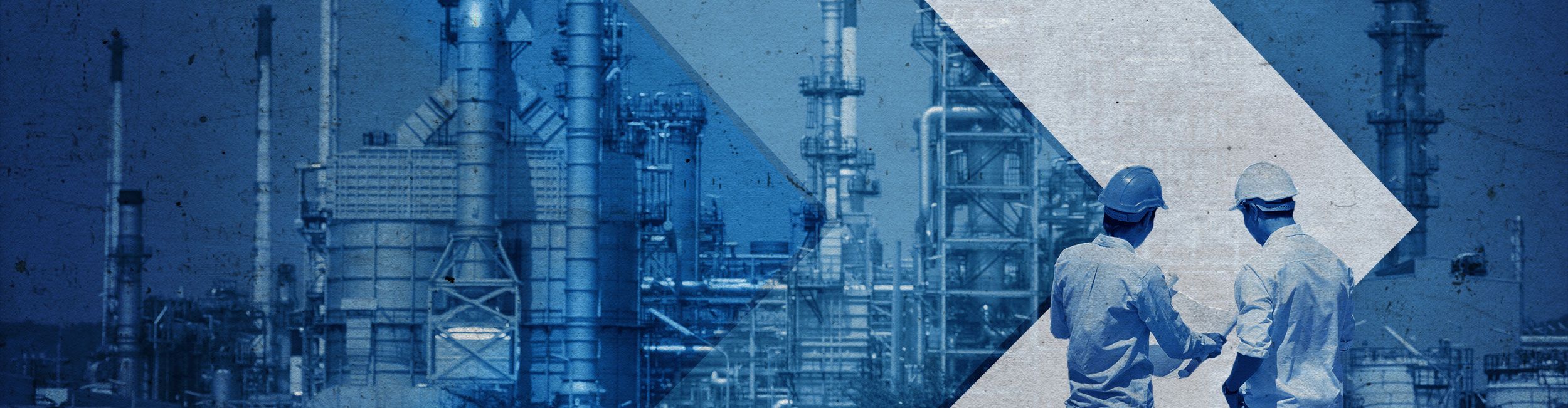 Two Cat workers in PPE looking at plans while overlooking an oil site shaded in blue