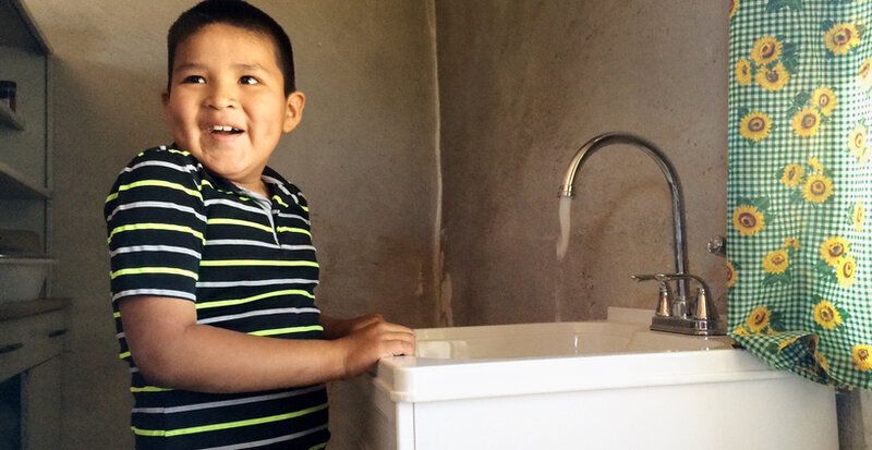Excited boy standing at sink
