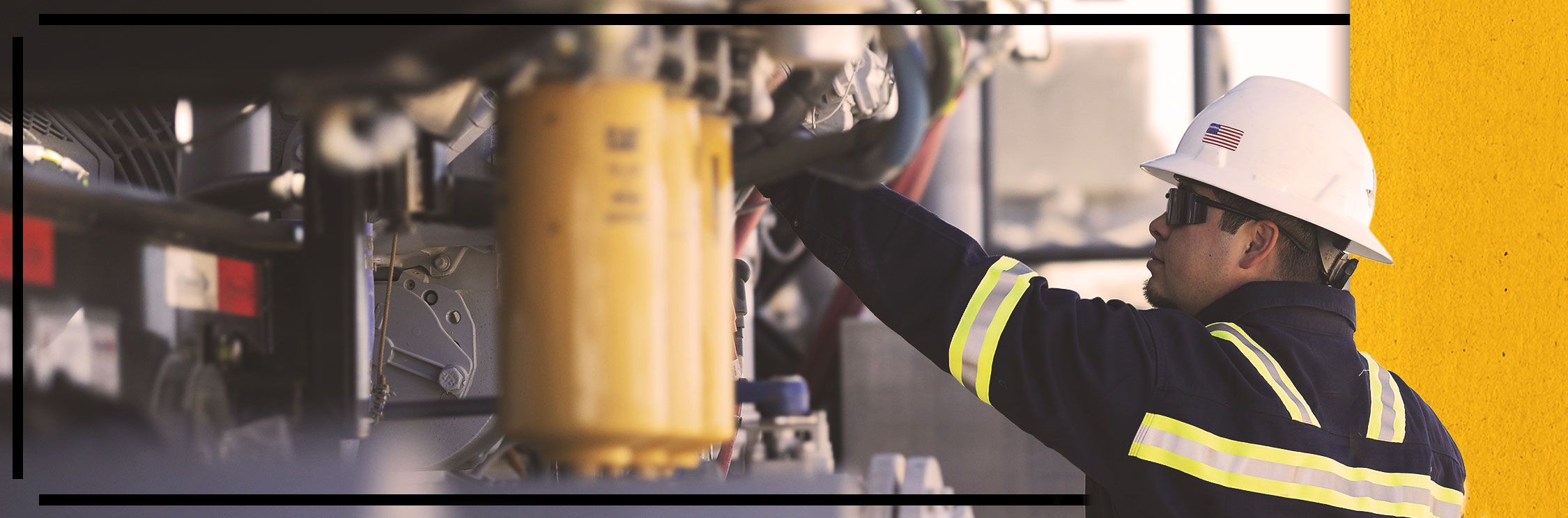 Close up of Cat worker in PPE examining a Cat engine