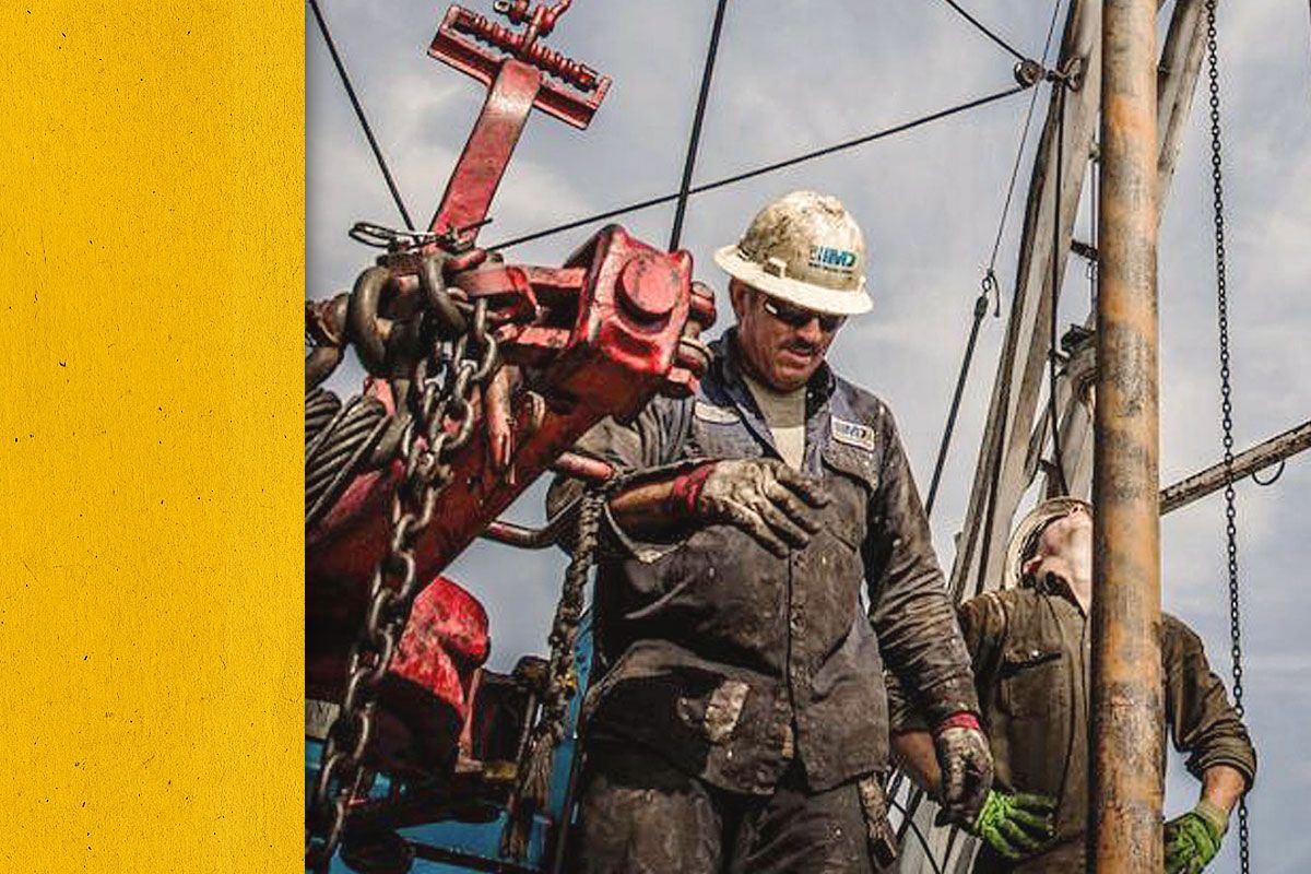 Close up of Cat workers in PPE installing an engine