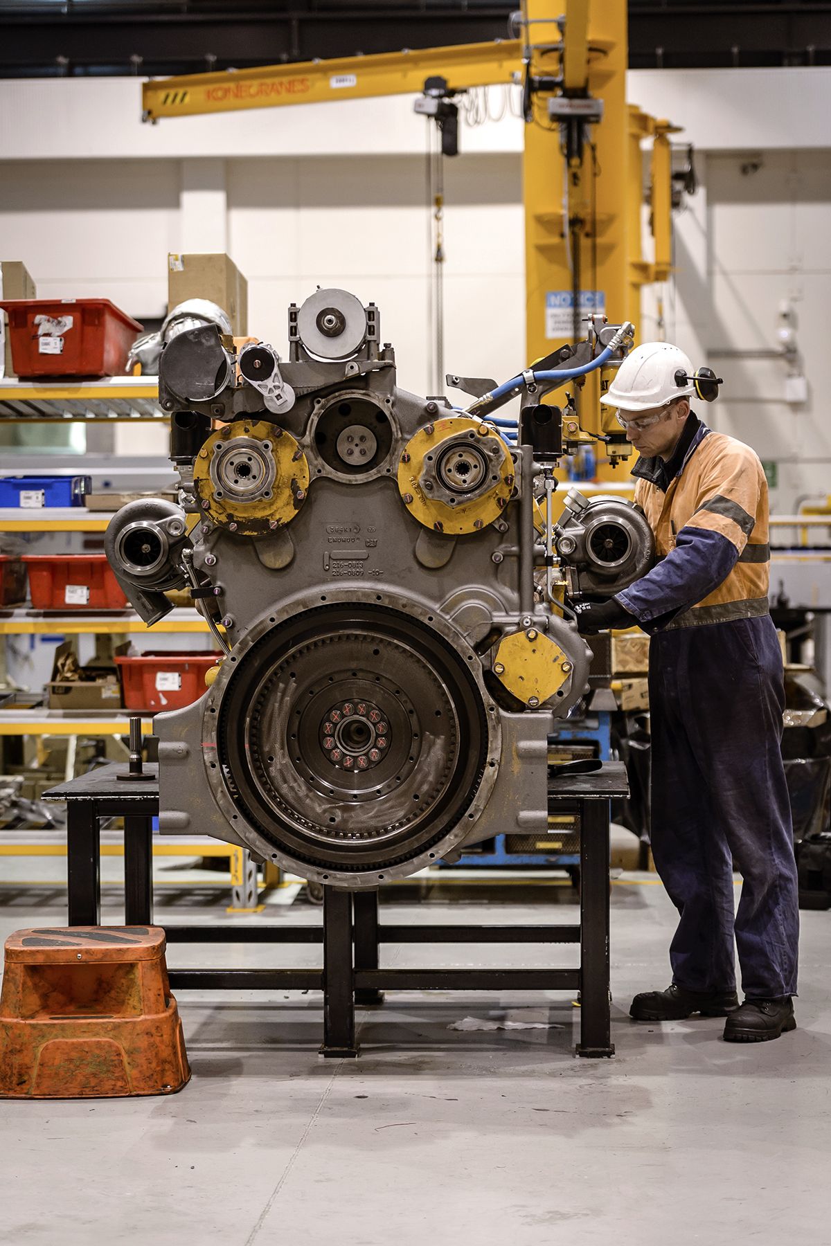 worker performaining maintenance on an engine