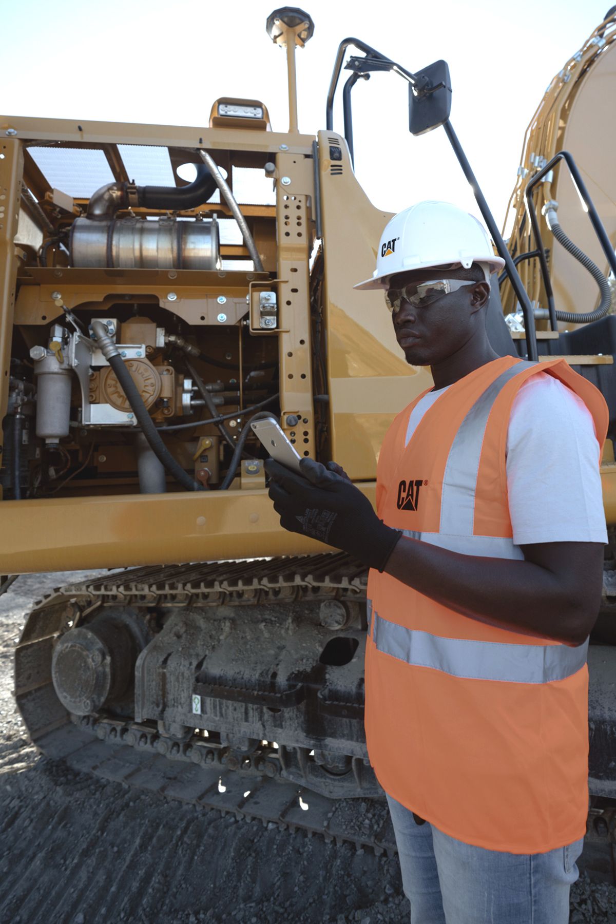 worker using a device in front of a machine