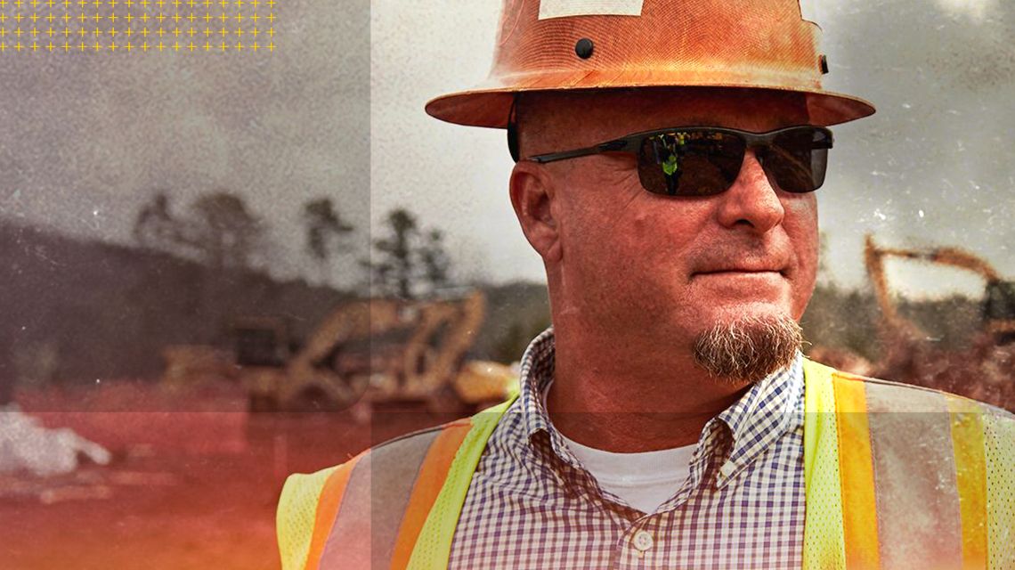 Person with sunglasses on a jobsite with machines at work in the background