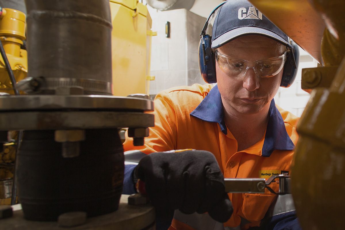Cat worker servicing machinery