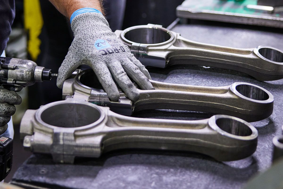 Close up view of gloved hands assembling reman parts