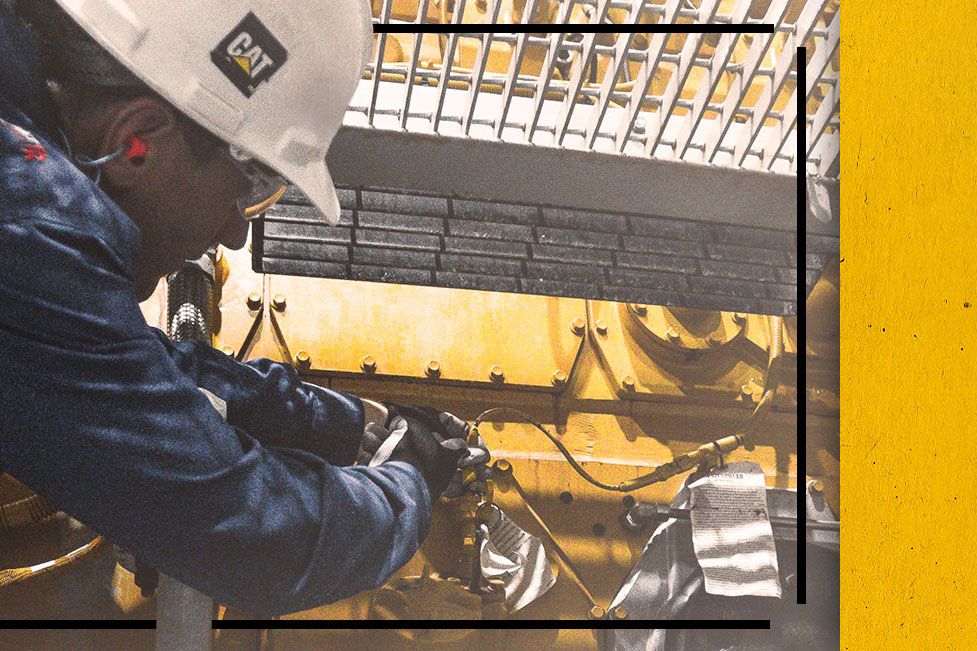 Close up of Cat worker in PPE fixing a Cat Engine