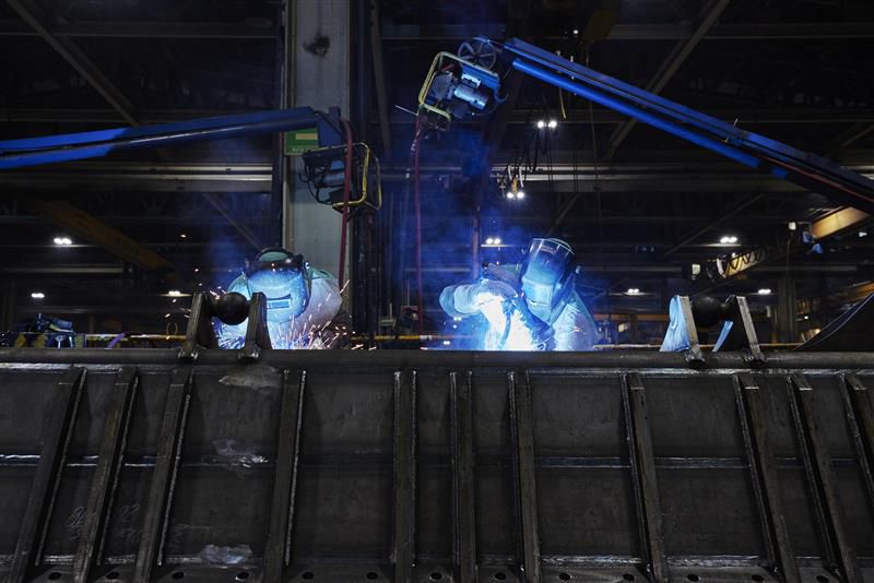 Two men welding in the dark