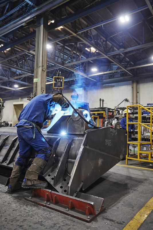 One man welding on an attachment